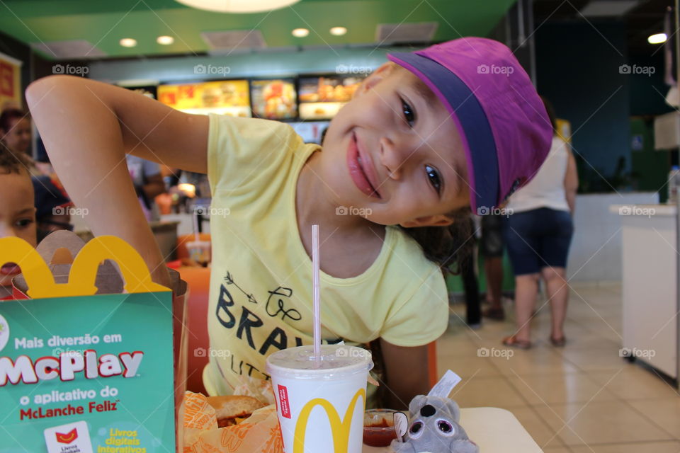 little happy girl eating at McDonald's