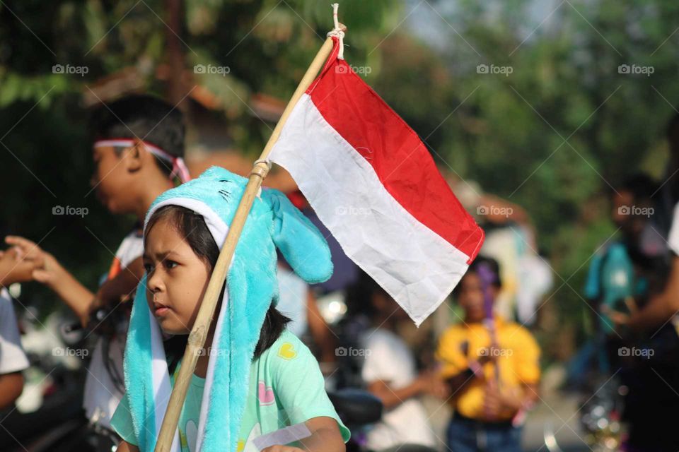 Indonesia, September 1, 2019 - young girl carryng Indonesian Flag during festival.