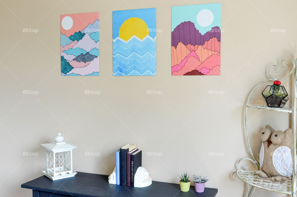 Graphic wall art series displayed above a table and shelving