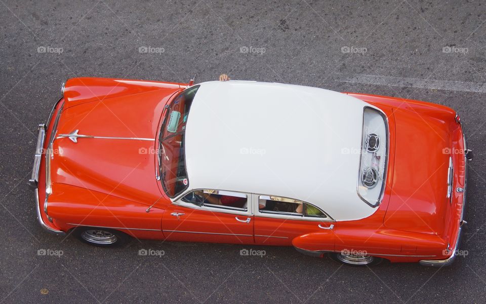 A bird's eye view of a two tone classic American car on the street in Havana, Cuba