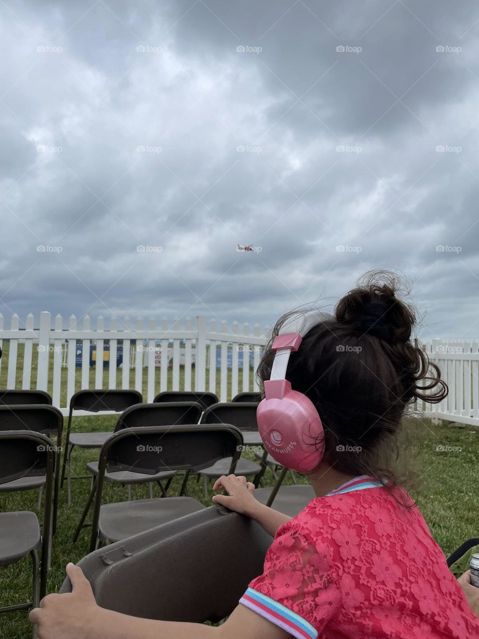 Little girl watches helicopter in the sky, little girl at Dayton Air Show, helicopter flying overhead, watching the helicopters fly at the air show 