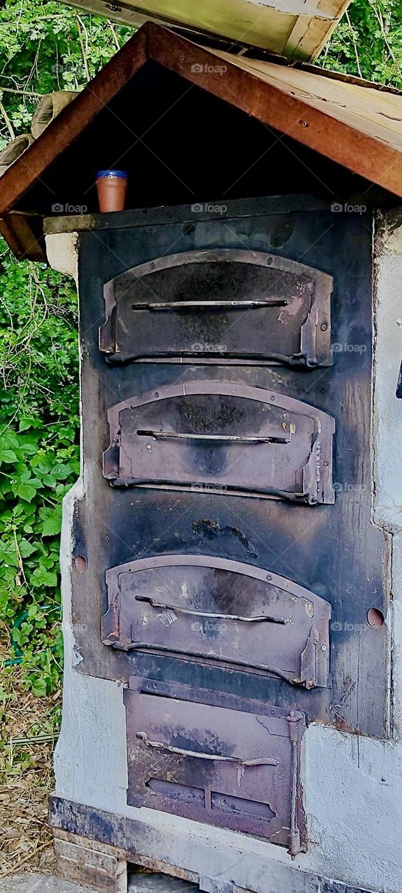 This is an old fashioned multi tiered cast iron oven with pullback drawers to retrieve either baked goods or cooked meals. It’s part of the “Renaissance Festival” of “Ortenburg” in “Bavaria” near the “Austrian” border. 2023. Hypnotic Productions