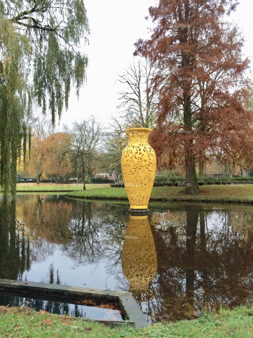A yelow vase in a parc