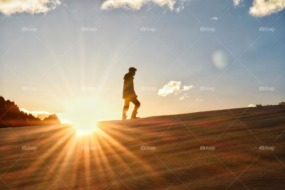 alone man walking on ridge against dramatic sky