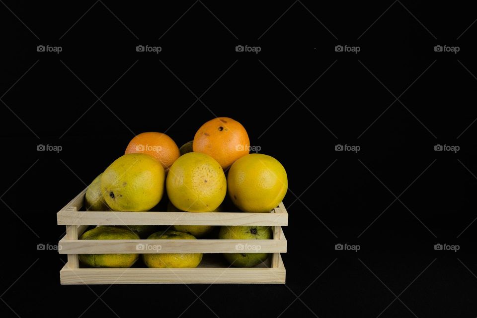 Fruit box with oranges on black background