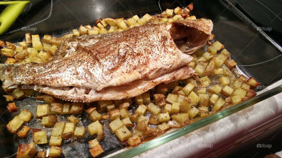 fish cooked in oven with bottom potatoes and leek cubes
