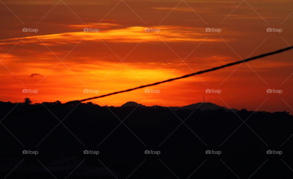 Sunset. At the side of district landscape at the afternoon of late. Crazy oranje dark of sky with the black colouring of mountain.