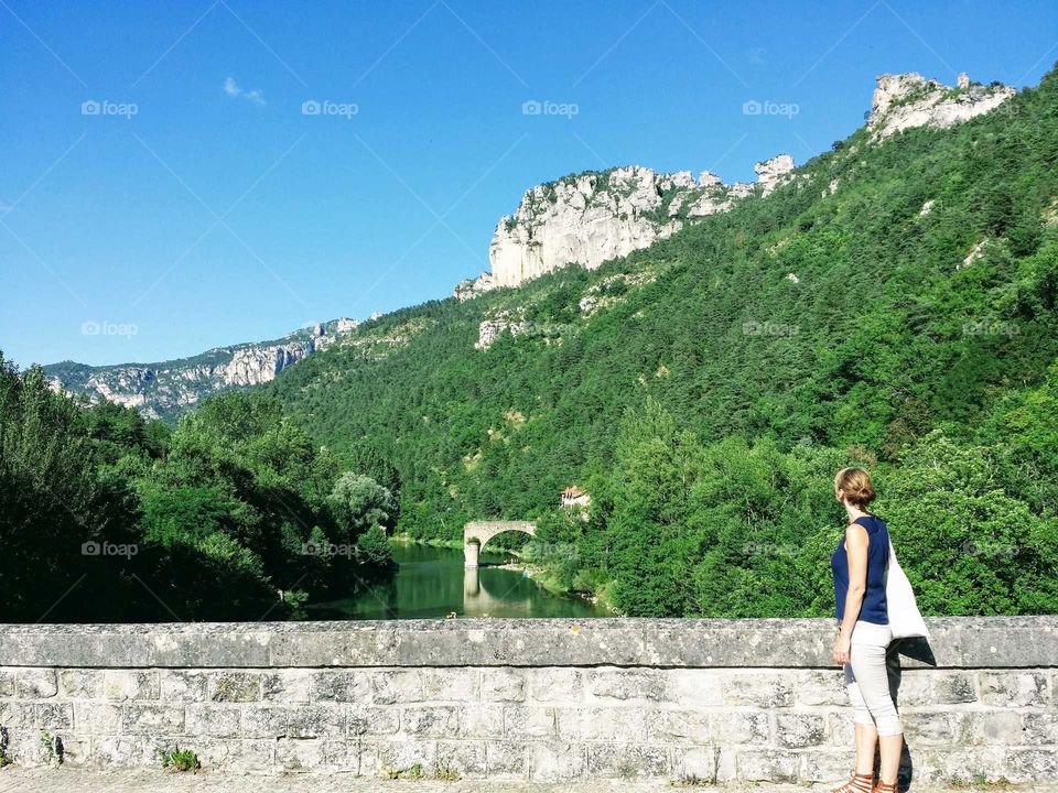 woman standing on bridge looking out over the landscape of Gorges du Tarn