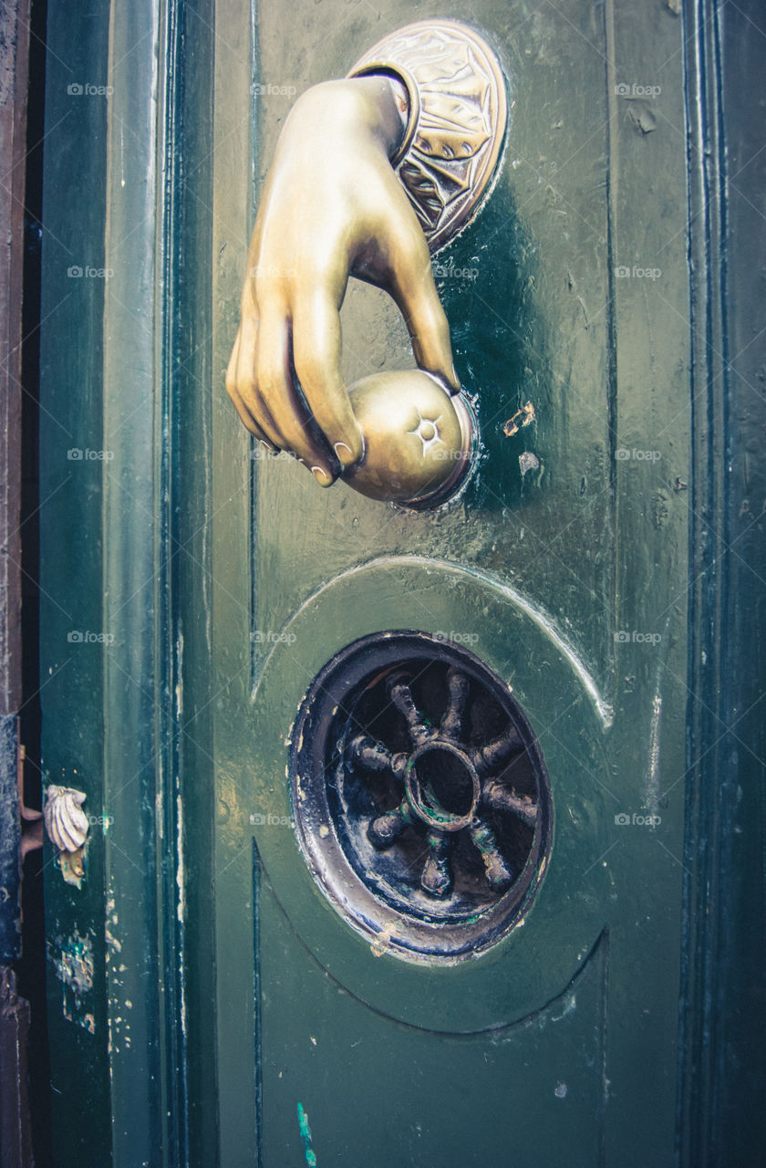 Metal knocker on green door