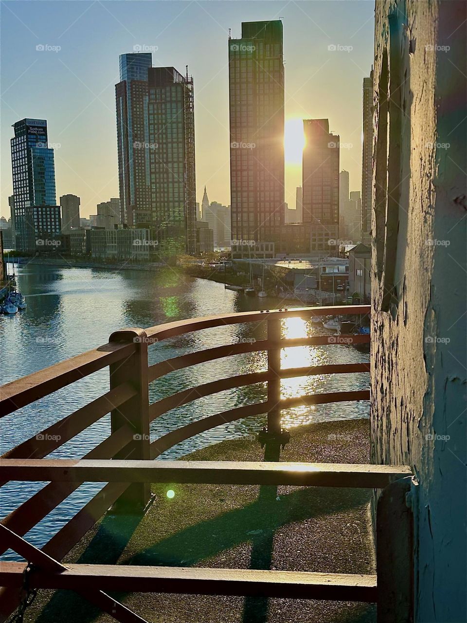 This is the central outpost of the „Pulaski Bridge“ at „Newtown Creek“ that connects „Greenpoint“, Bklyn to LIC in the intense light of the setting sun. Across the „East River“ in the distance we see LIC and „Manhattan“. 2024. Hypnotic Productions