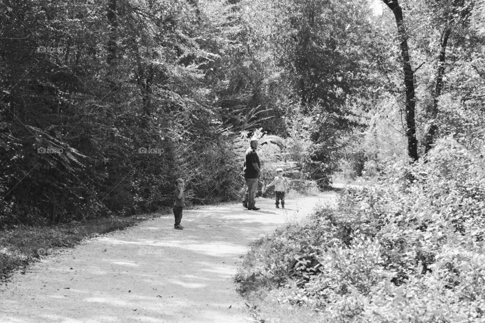 Pawpaw and grandboys walking on a path in the woods done in black and white