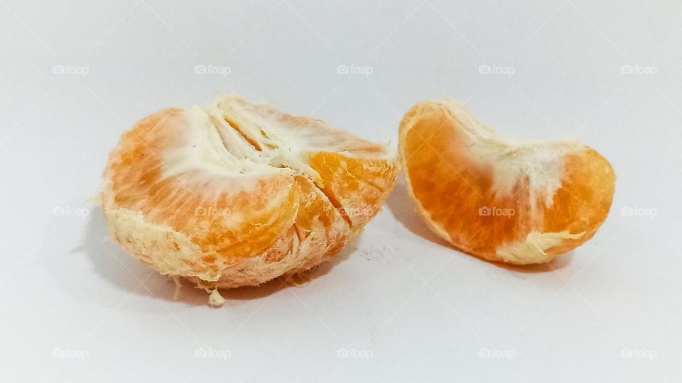 Orange fruit halves on white background isolated in eye level view