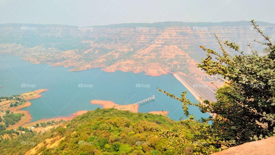 Dam with water storage surrounding by mountains.
