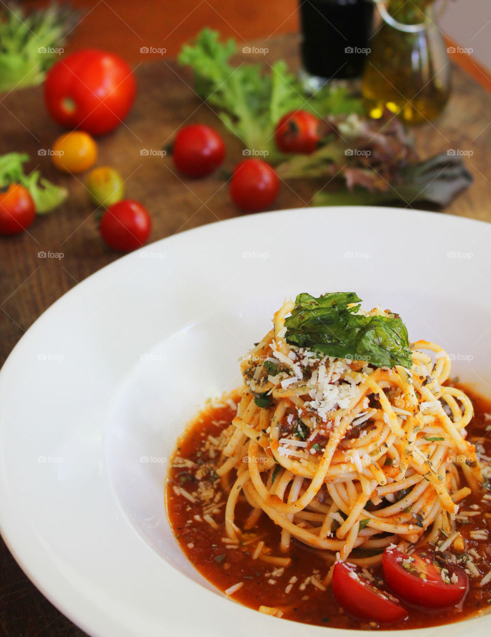 spaghetti with tomato sauce on a white plate above wooden table with garnished