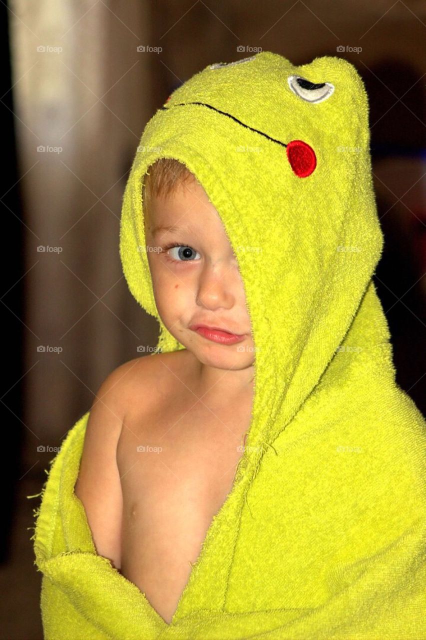 Close-up of a little boy wrapped in towel