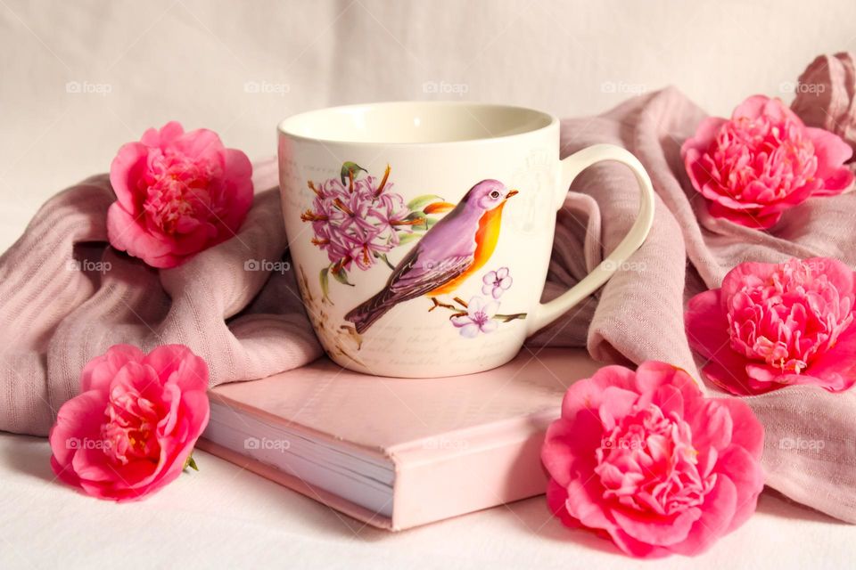 Pink book, mug and flowers