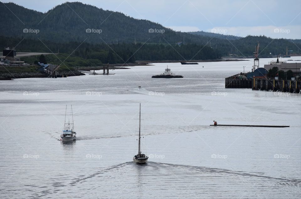 Small boats follow our cruise ship pulling out of an Alaskan port