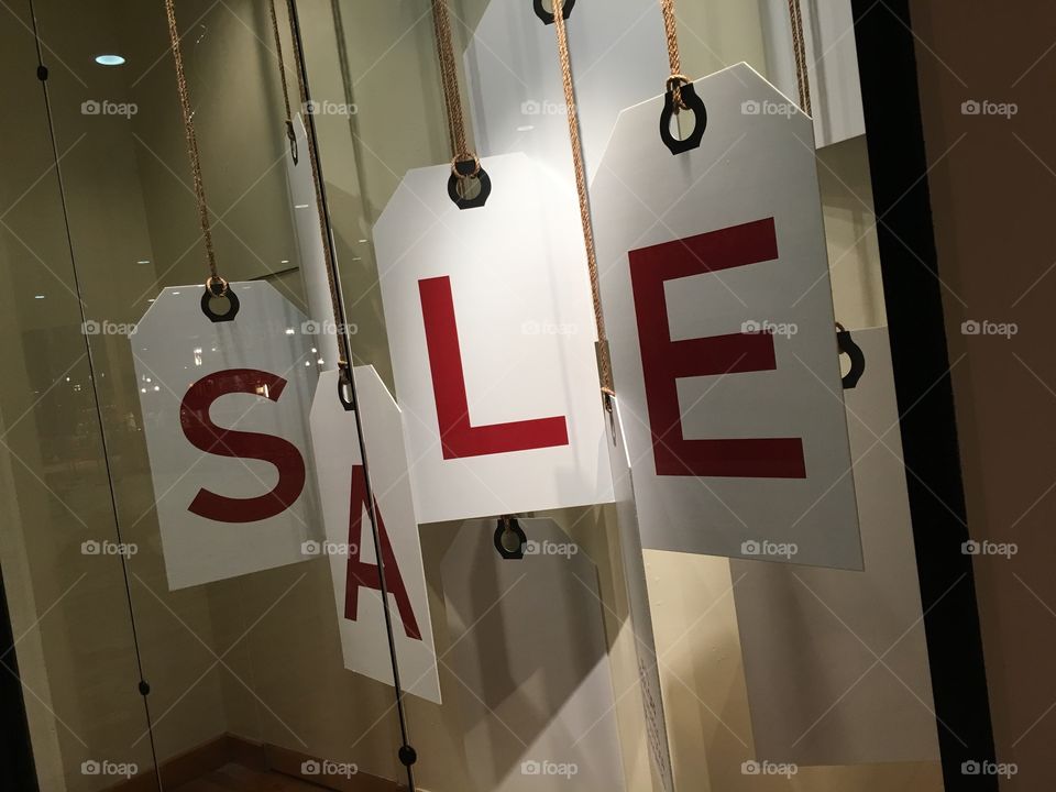 A creative sale sign in a retail shop window display.
