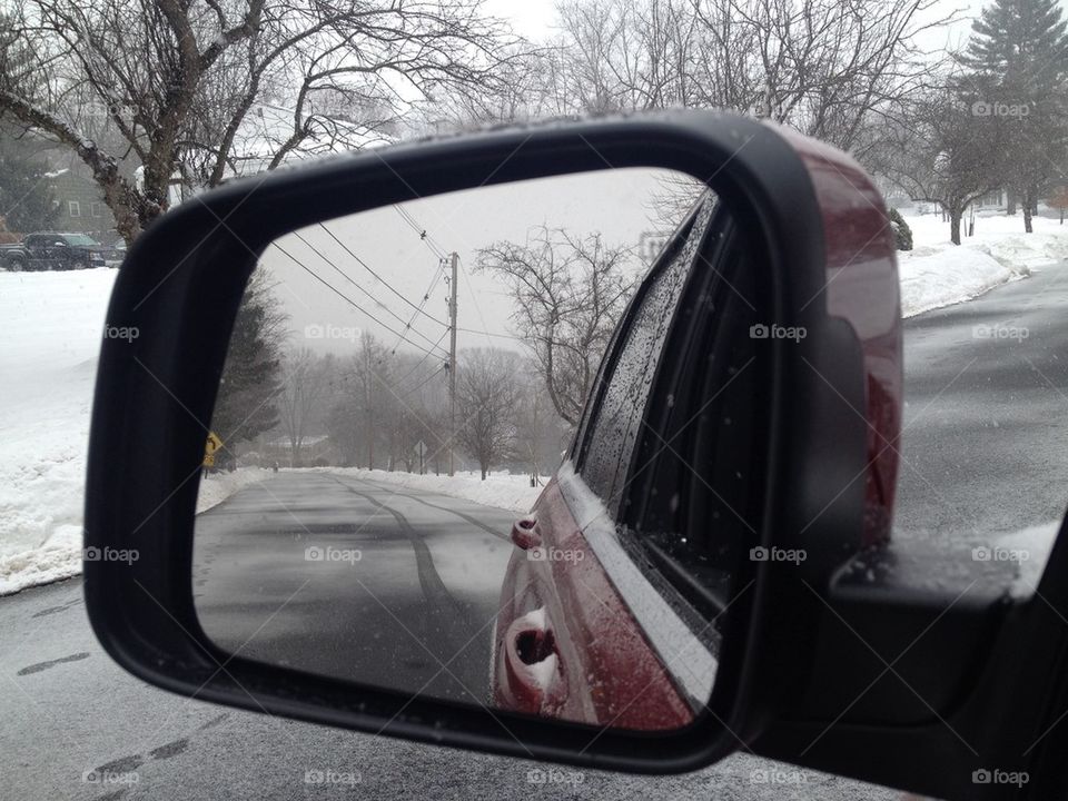 snowy road in side view mirror