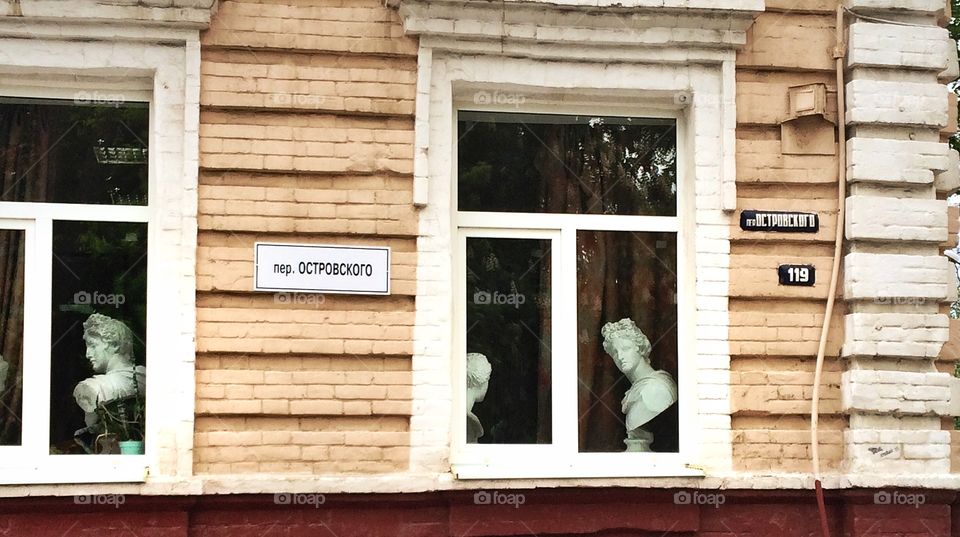 Alabaster heads. . I was driving by when stopped at a traffic light. Looked on my left and saw those figures at windows. It was art school