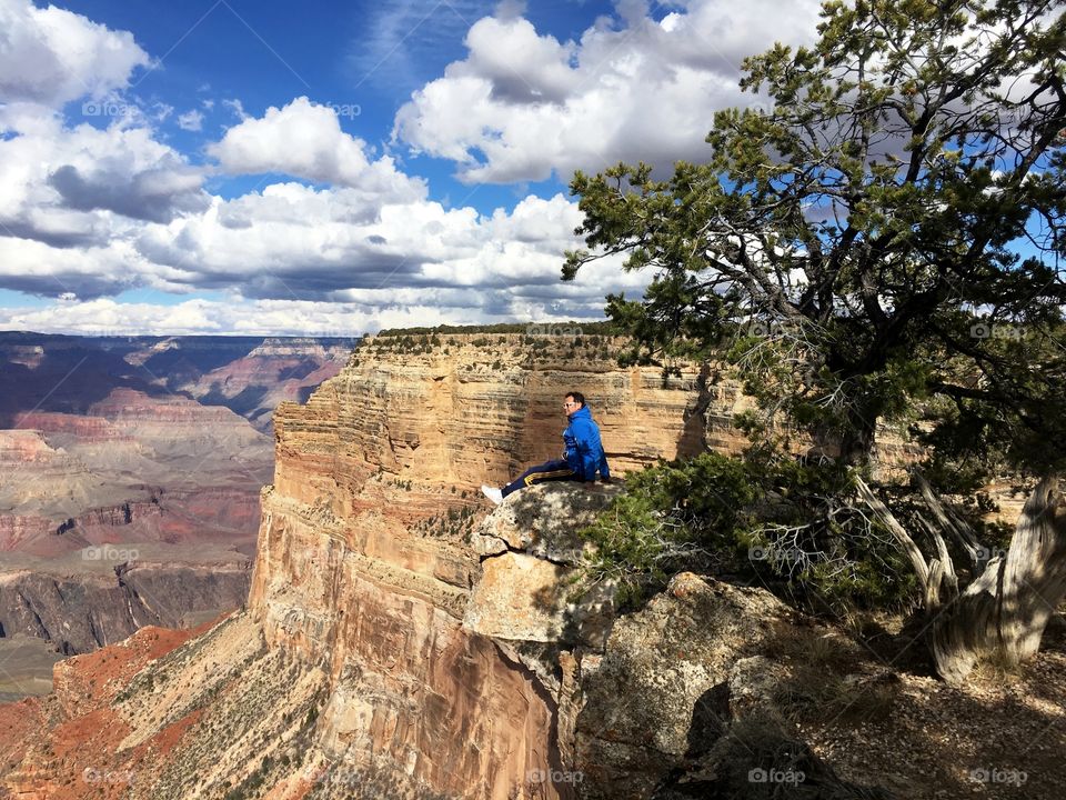 a man relaxing and looking the Grand Canyon