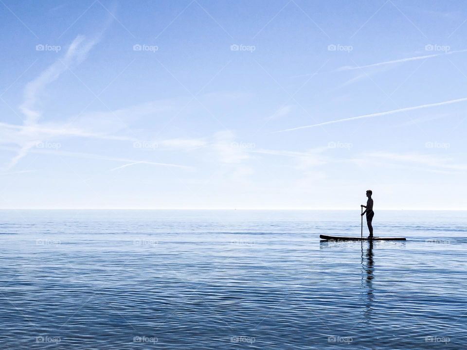 Silhouette of a person doing SUP