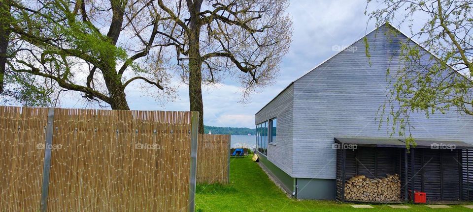 This house next to the unusually barren tree for the summer season is located on the shore of a large freshwater lake known as the “Starnberger See” in the vicinity of the small town of “Starnberg” in rural “Bavaria”. 2023. Hypnotic Productions
