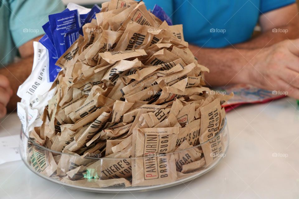 Pile of sugar packs in a plate