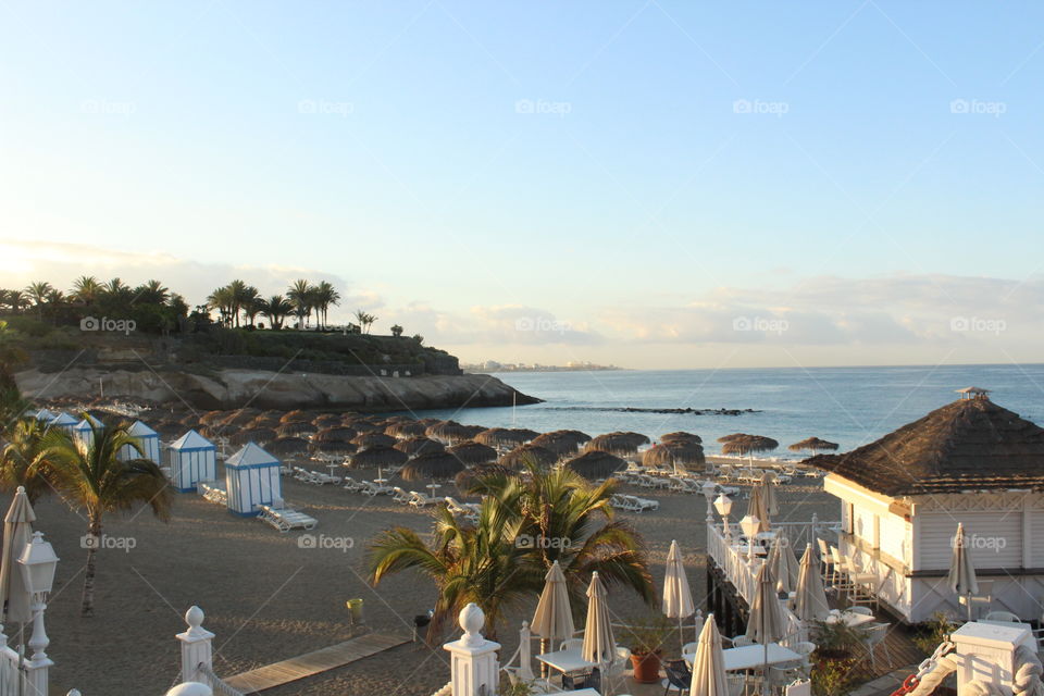 Morning resort view of beach umbrellas along the coast.