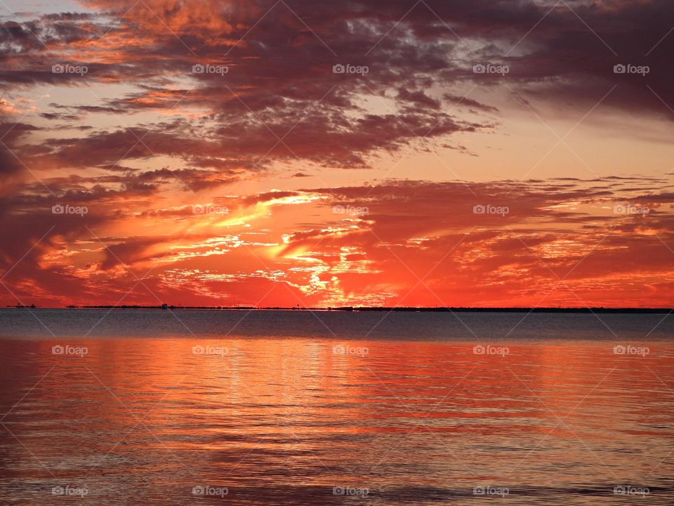 Beautiful swirling clouds over the ocean at sunset - Cloud iridescence or irisation is a colorful optical phenomenon that occurs in clouds that appear in the general proximity of the sun or moon