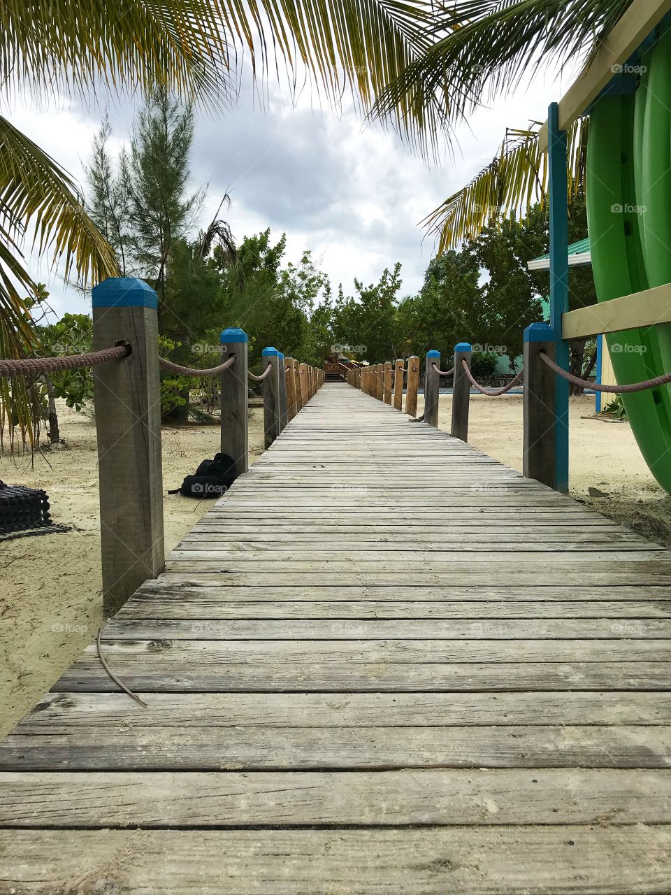 Long wooden path on a tropical island with palm trees