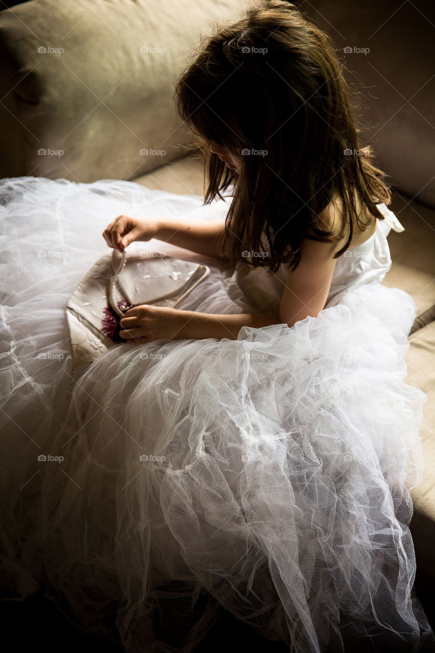 Monochrome image of girl playing wearing mom's wedding dress -interesting lighting and shadows