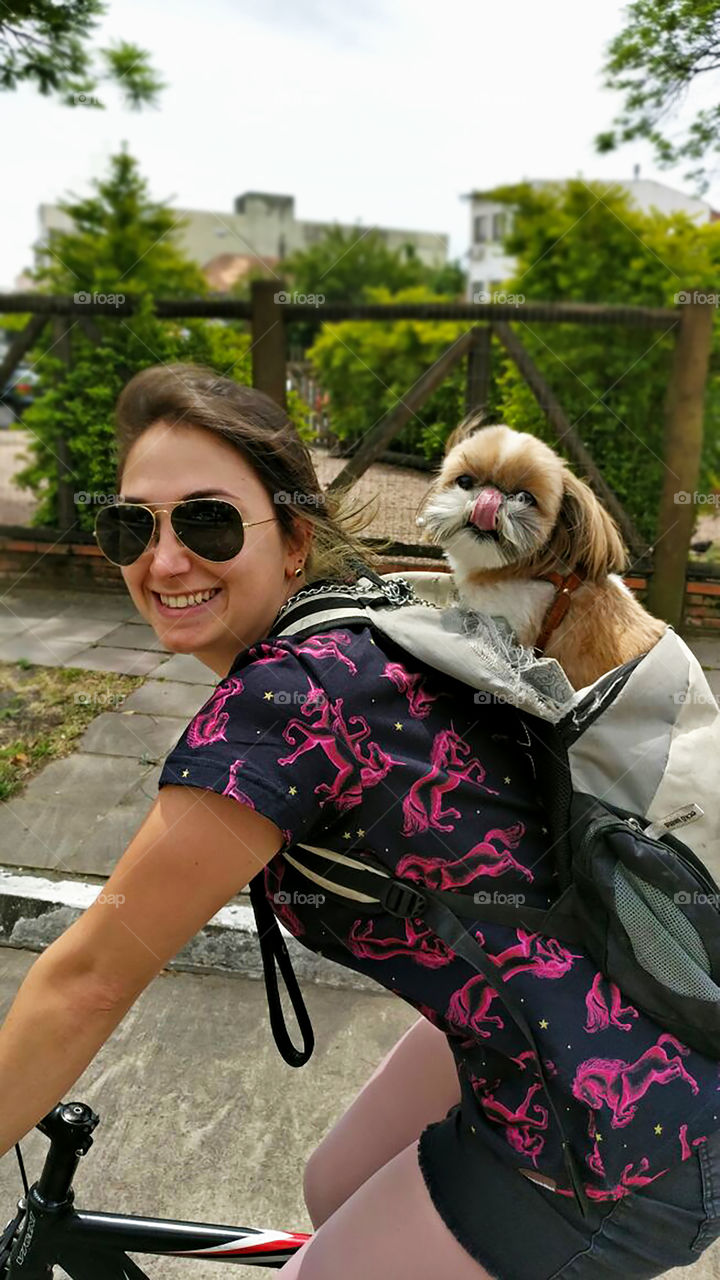 Girl riding with her adorable shihtzu dog