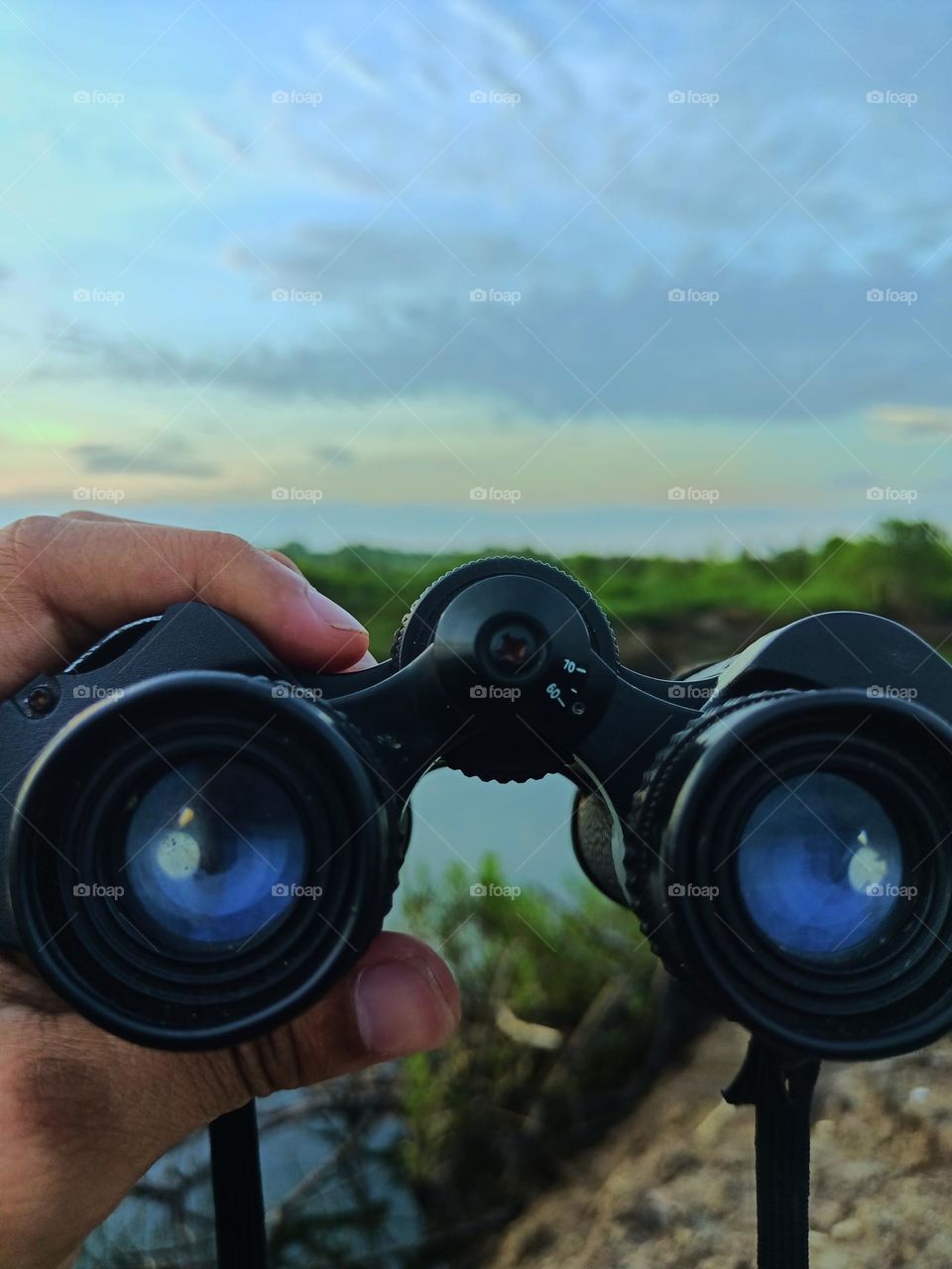 Hand man hold binoculars on a beautiful day on the river, binoculars sailor