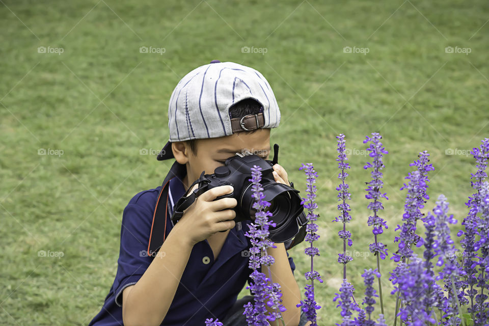 Hand boy holding the camera Taking pictures in park.