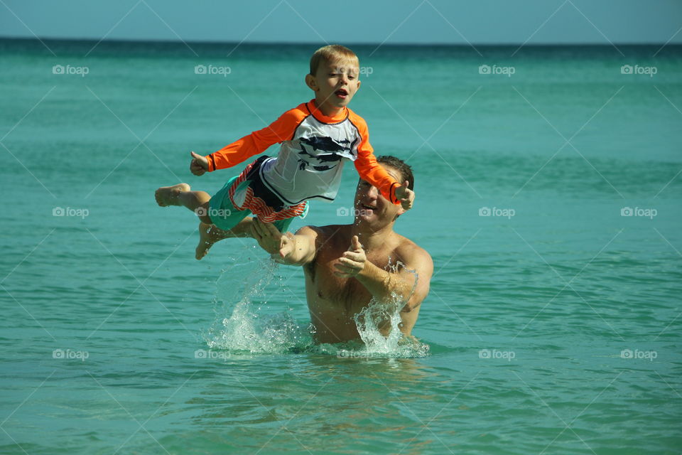 father playing with his son in the sea