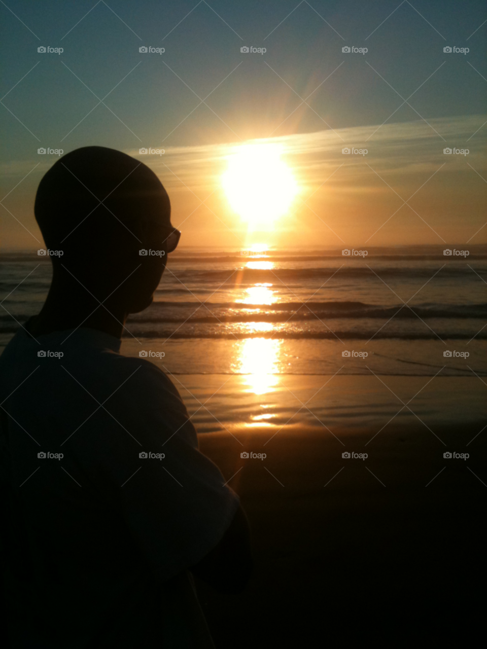 Gaze. Silhouette of young man sunset gazing on the beach, Oregon Coast.