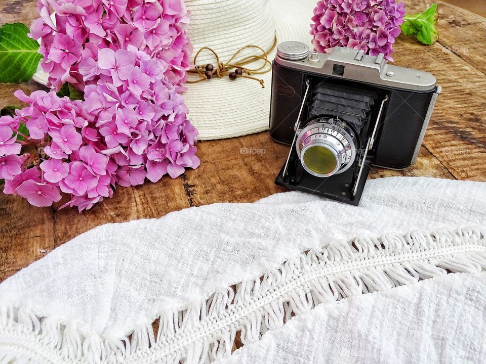 Still life with old camera and summer hat