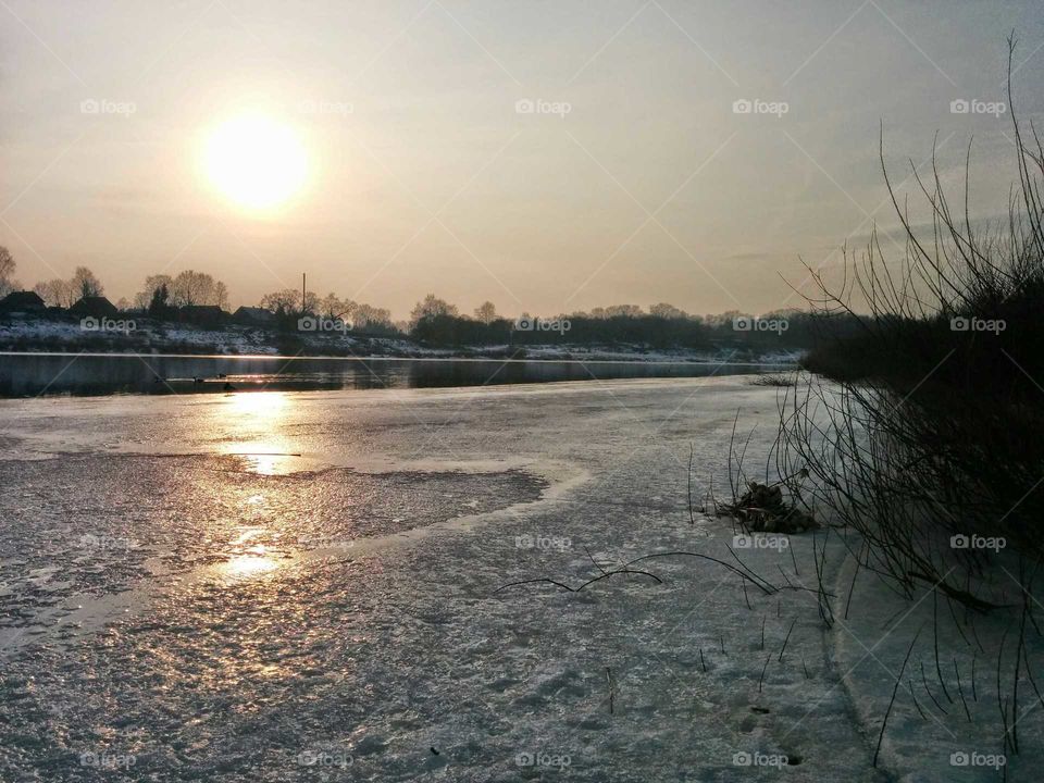 Winter iced river and sunset