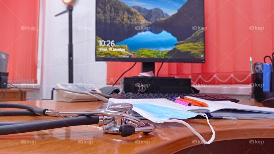 Doctor's desk, computer desk,monitor, blinds, orange,magazines,pens,phonendoscope,medical mask,doctor's office, reception room