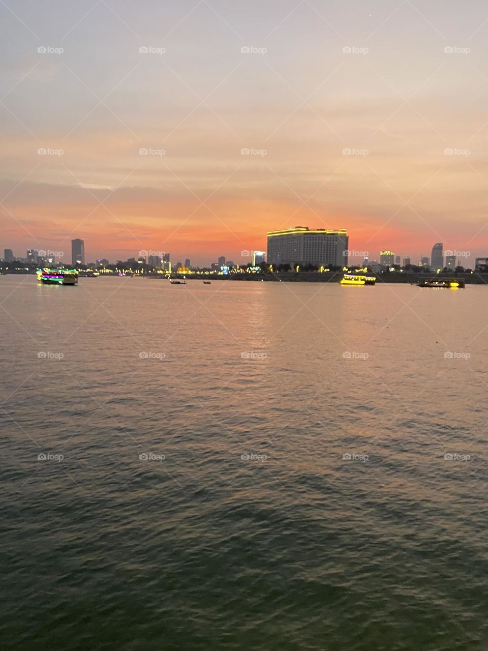 Sun setting behind phnom phenn city with river view 