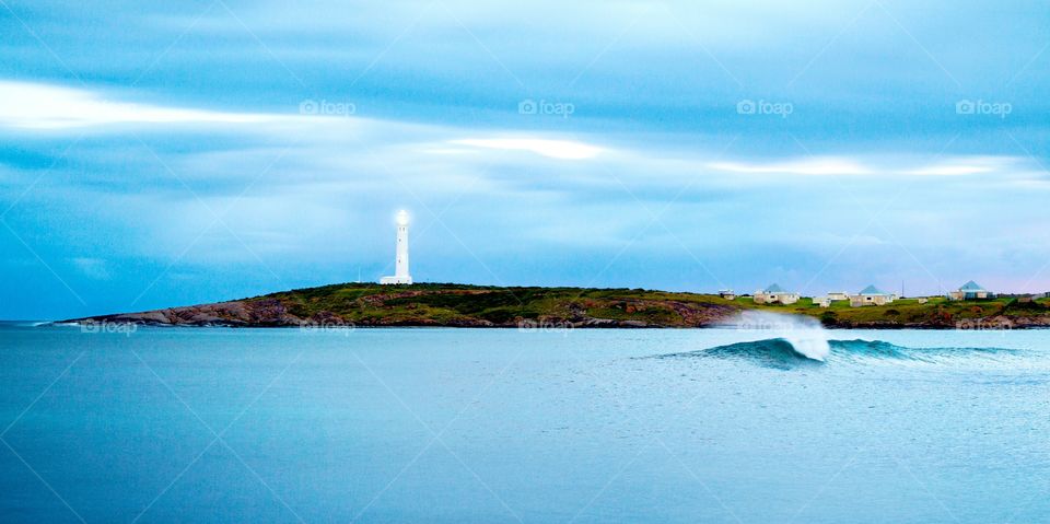 Cape Leeuwin lighthouse and a wave in the bay at Augusta in South West Western Australia