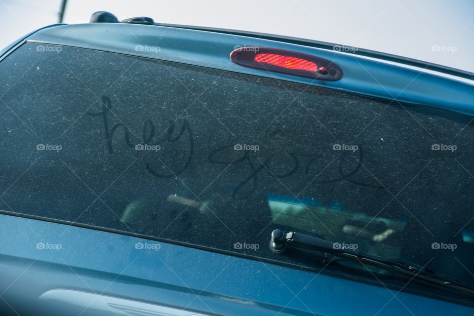 Hey girl written on a dusty windshield 