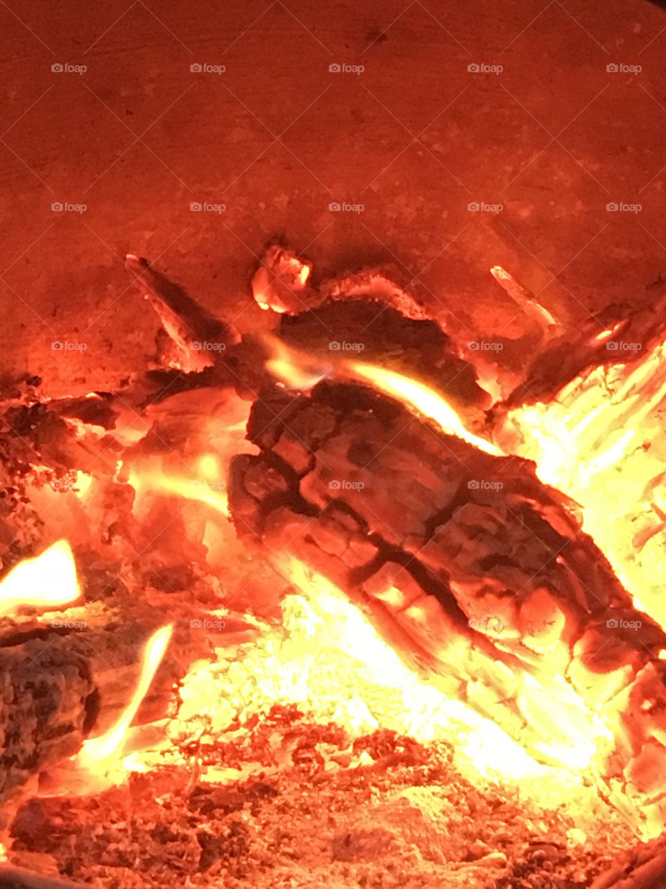 Wooden logs with flames burning on a fire in a chiminea in the garden outside