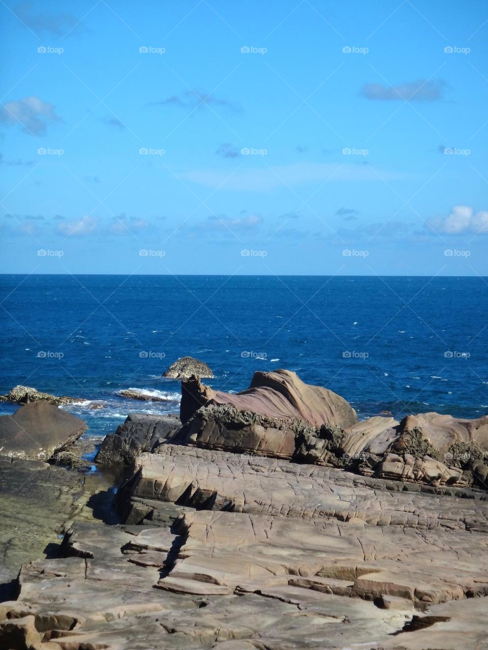 Coast with clear ocean and  blue sky and stones