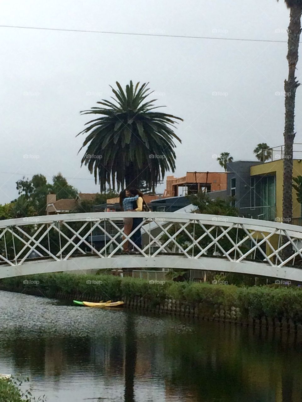 Venice is for lovers. Couple kissing on a bridge in Venice, CA.