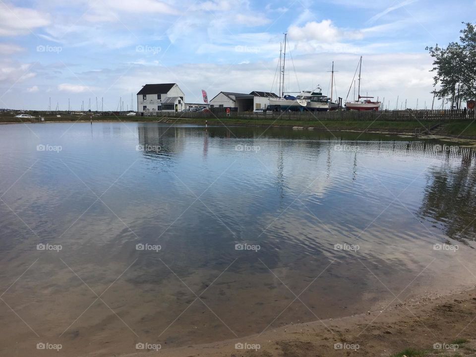 Natural salt pool lake Essex countryside reflection with boatyard 