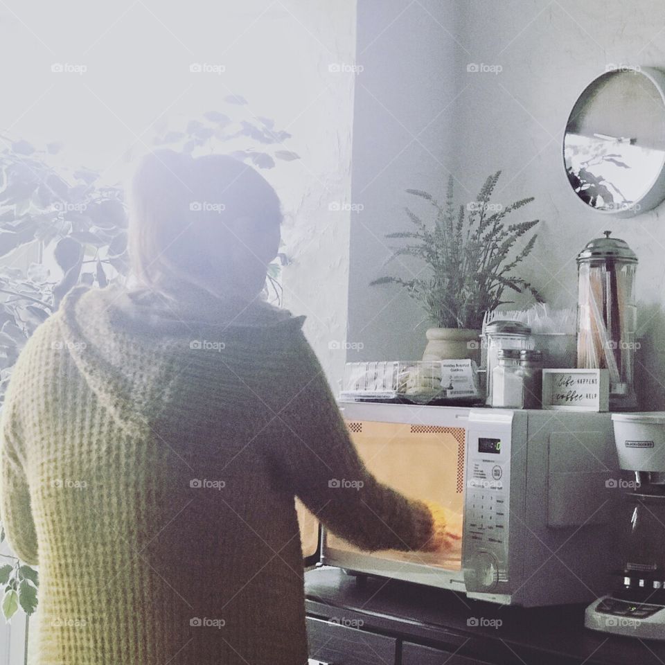A young woman using the microwave 