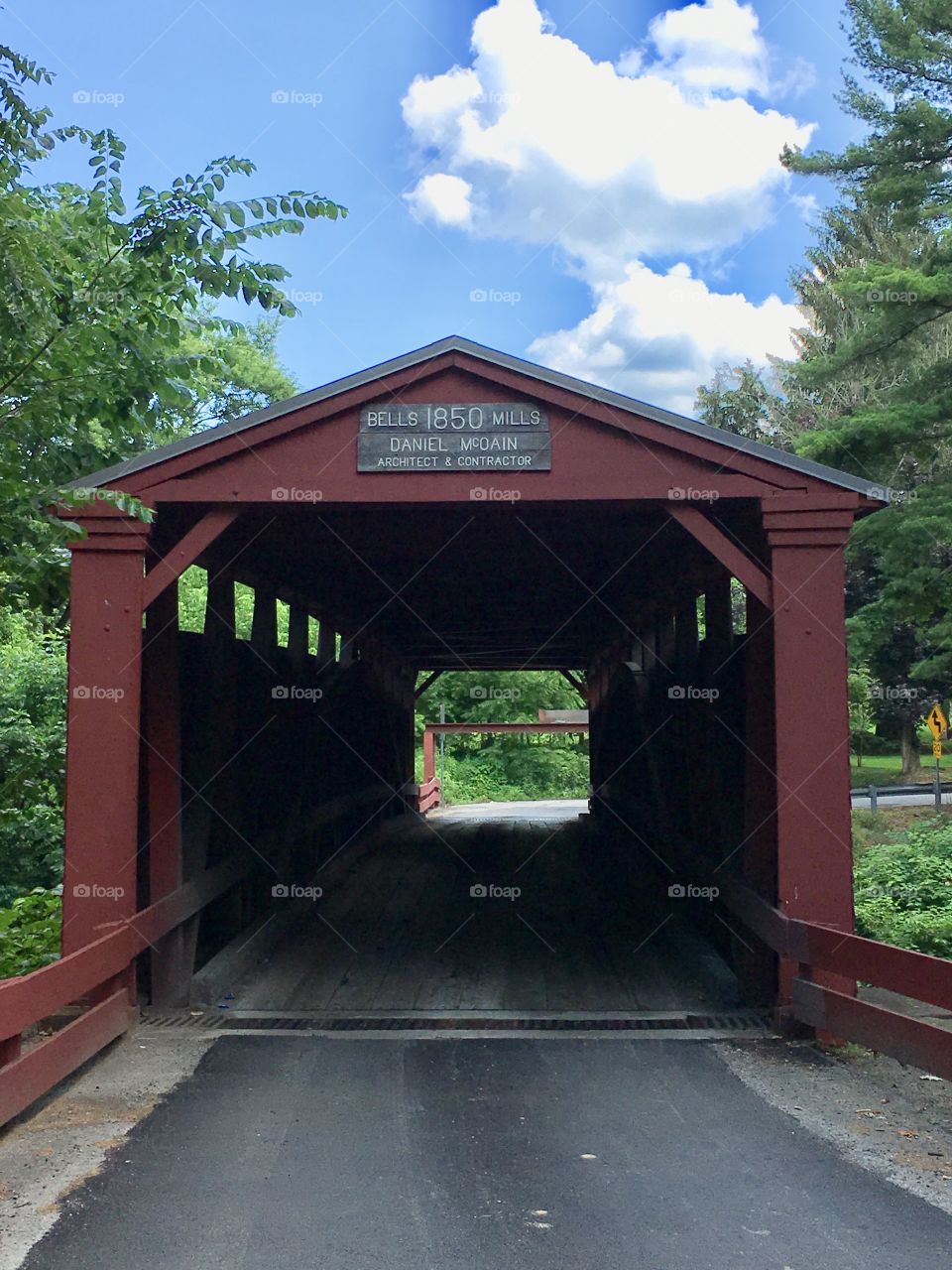 Summer view of covered bridge over water 