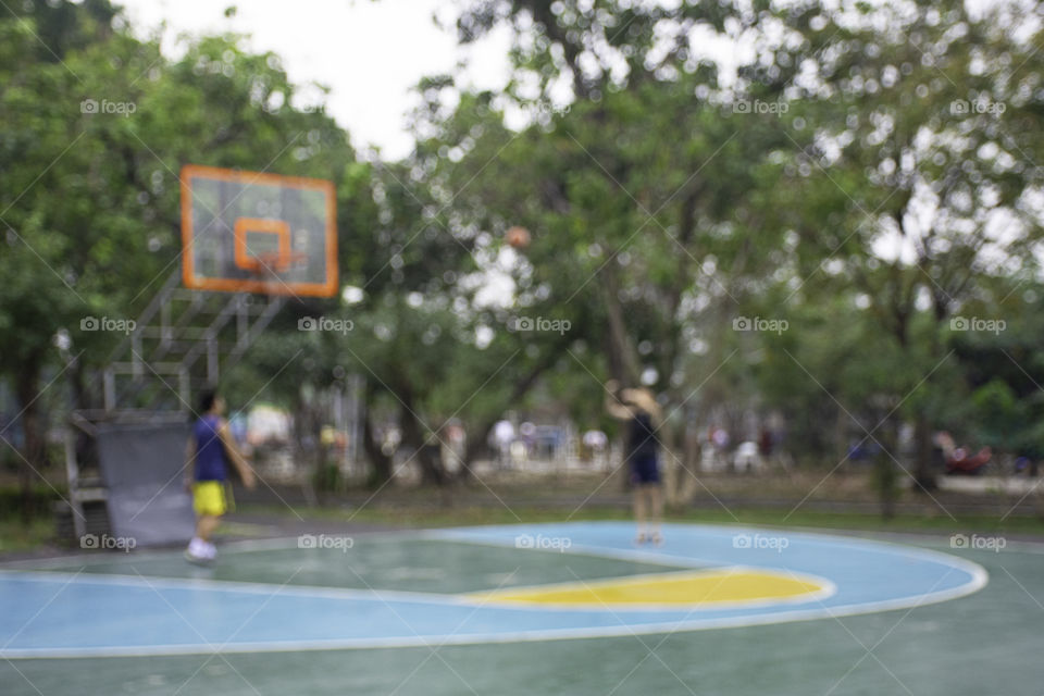 Blurry image teens playing basketball in the morning at BangYai Park , Nonthaburi in Thailand.